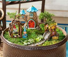 a potted planter filled with miniature gnomes and houses on top of it