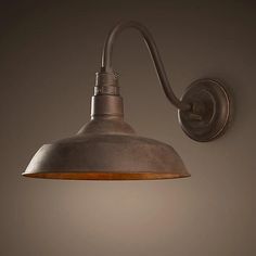 an industrial style wall light with a metal shade on the side and a wooden base