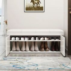 a white bench with shoes on it in front of a painting hanging above the shoe rack