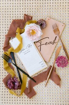 a place setting with flowers, napkins and utensils