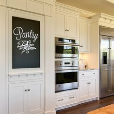 a kitchen with white cabinets and stainless steel appliances, along with an advertisement on the wall