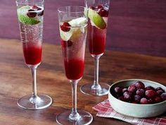 three wine glasses filled with fruit on top of a wooden table