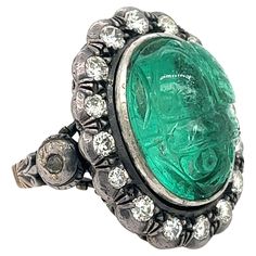 Antique Victorian 15-carat carved emerald and round cut diamond halo in 18k gold and silver. The emerald is hand carved into an intricate beetle motif, bezel set with an open back ring shank. Allowing for the vibrant natural color of the emerald to display without hindrance. The carved emerald is complemented with 16 round cut diamonds and 2 rose cut diamonds on the ring shank. This ring is an antique wonder. So much character and class. Become a part of history with this unique, Victorian-era m Carved Emerald, Ring Shank, Halo Diamond Ring, Antique Diamond, Halo Ring, Halo Rings, Diamond Halo, Rose Cut Diamond, Antique Victorian