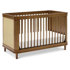 a wooden crib with white sheets on the bottom and side rails, against a white background