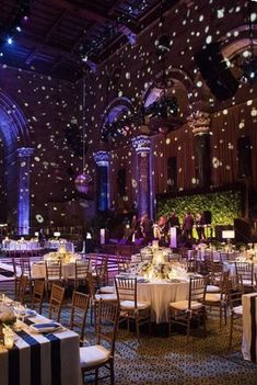 a large room with tables and chairs covered in confetti falling from the ceiling