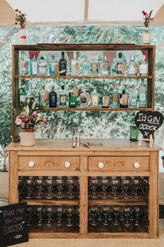 a wooden cabinet with bottles and glasses on it next to a sign that says, just call occupant