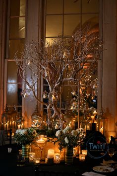 a table topped with candles and a tree