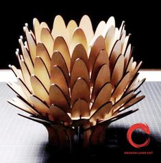 a paper sculpture made to look like a flower on a table with the words dragon laser cut above it