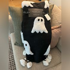 a black and white bag with ghost faces on it sitting on top of a couch