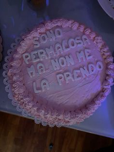 a pink cake with white frosting that says, sono permaglosh no non me la prendo