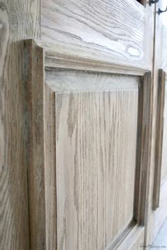 closeup of the wood grains on an unfinished cabinet door with metal handles and knobs