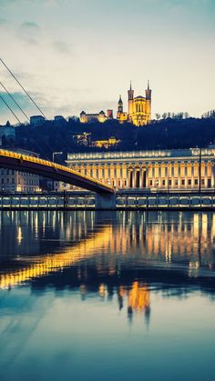 a bridge that is over some water with a building in the background