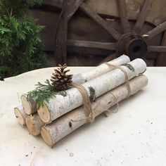 three logs stacked on top of each other with a pine cone sitting on top of them