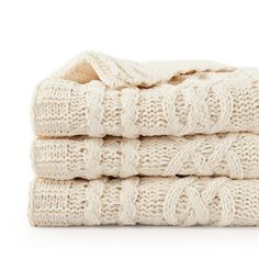 three white towels stacked on top of each other in front of a white background,