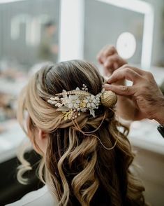 a woman is getting her hair done by someone