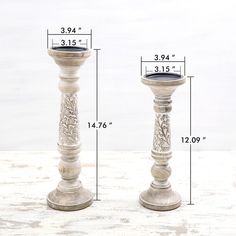 two tall white candlesticks sitting next to each other