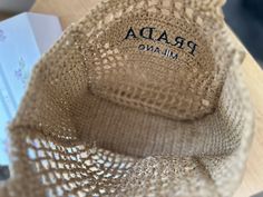 a close up of a bag on top of a wooden table next to a book