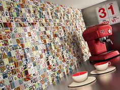 a red coffee maker sitting on top of a counter next to cups and saucers