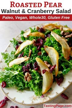 a white plate topped with kale salad covered in apples and cranberries on top of a table