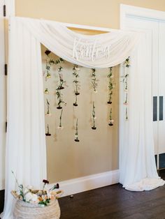 a white wedding arch with flowers hanging from it