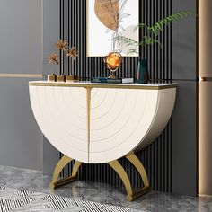 a white and gold sideboard with plants on it in front of a black striped wall