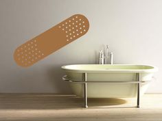 a bathtub with a large brown adhesivement sticker on the wall next to it