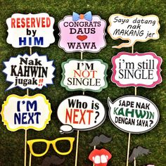 a bunch of signs that are on top of some sticks in the grass with words