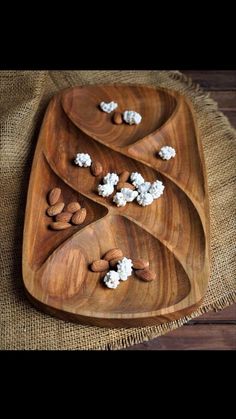 three wooden trays filled with nuts and marshmallows on top of burlap