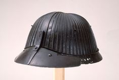 an old black helmet on a wooden stick