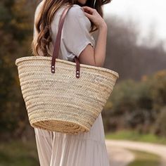 a woman carrying a large woven basket on her shoulder