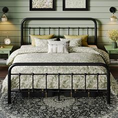 a bedroom with green walls and pictures on the wall above the bed, along with two nightstands