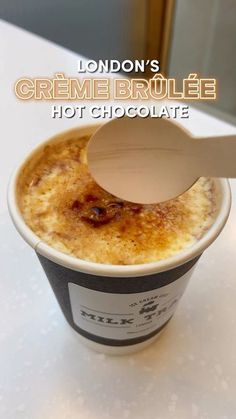 an ice cream sundae with a spoon in it and the words london's creme brulee hot chocolate