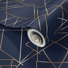 a blue wallpaper with gold lines and shapes on it's surface, as well as a roll of tape