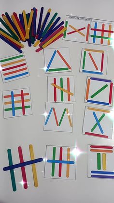 several pieces of colored stick art on a white surface