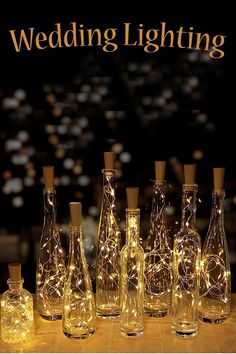 there are many bottles with lights in them on the table next to eachother