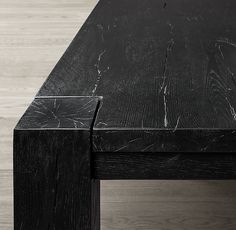 a close up of a wooden table with black paint on the top and wood flooring