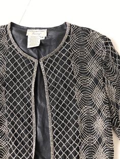 I see these beaded jackets a lot, but it’s rare to find a silk one in perfect condition that is as chic as this! I love the teeny delicate beads, as well as the gorgeous pattern.  It gives me major spiderweb vibes.  This is perfect for your holiday zoom, or over your favorite t-shirt and jeans. Item details:- amazing beaded pattern- black silk- polyester lining- hook and eye on front- “Papéll Boutique” labelBest fits a size small - medium.Measurements:bust: openlength: 23”shoulder: 17”sleeve: 25 Embellished Fitted Cardigan For Party, Elegant Beaded Festive Outerwear, Elegant Beaded Outerwear For Spring, Embellished Fitted Cardigan For Evening Wear, Fitted Beaded Outerwear For Fall, Fitted Embellished Cardigan For Evening, Festive Fitted Beaded Outerwear, Fitted Beaded Evening Outerwear, Fitted Embellished Evening Cardigan