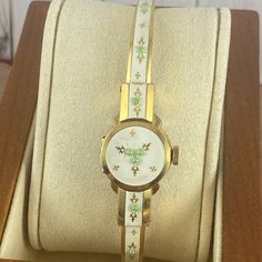 Vintage 1950's Flip Top Bucherer 17 Jewels Swiss Ladies Floral Enameled Cuff Wrist Watch 18k Heavy Gold 10 Micron Gold Plated Marked By Inside Back Underside 12 O'clock. Hinged Case Lid Stays Tightened. This Bucherer Watch Has A Larger Crown, Runs, Hand Wind, Gold Fleur D'alain, Raised Green Dots, Cream Enamel. Has A New Crystal, There Are Some Very Light Scuffs To Bracelet It Has Good Springs And Can Fit Up To A Size 6.85 Marked 36u C-Cr Excellent Condition As All Vintage Watches Slight Variation In Time Keeping Can Be Off Tested For 8 Hours Keeping Time Womens Watches Vintage, Vintage Yellow Gold Watch With Bracelet Strap, White Retro Watch For Formal Occasions, Retro White Watches For Formal Occasions, White Retro Formal Watch, White Retro Formal Watches, Vintage Timepiece, Italy Outfits, Cuff Watch