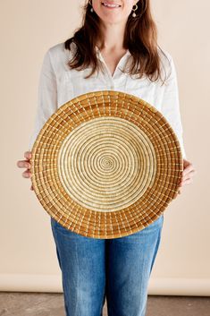 a woman is holding a woven basket in her hands