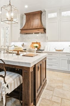 a large kitchen with an island in the middle and two chairs at the counter top