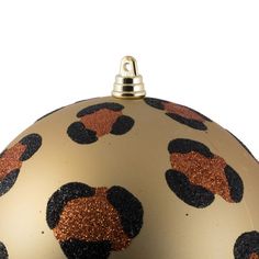 a gold ornament with black and orange designs on it