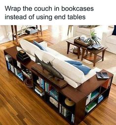 a couch sitting on top of a wooden floor next to a book shelf filled with books