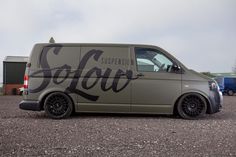 a van that has been painted with the word coca on it's side and is parked in a gravel lot