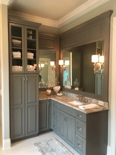 a bathroom with gray cabinets and marble counter tops