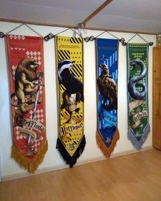 several harry potter themed banners hanging on a wall in a room with wood floors and cabinets