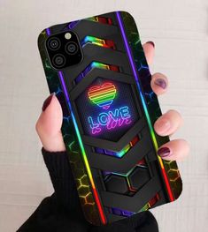 a woman holding up her phone case with the words love is alive on it in neon colors