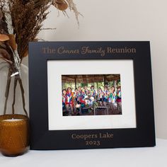 a group of people standing in front of a framed photo