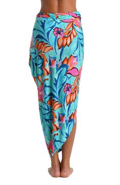 This pareo cover up features a vibrant and tropical floral print with a mix of teal, blue, pink, and orange hues, creating a lively and eye-catching pattern. The bold use of color and the large-scale floral motifs give the piece a fresh and summery feel. The sarong-style look with a faux wrap at the side offers a chic silhouette, looking equally beautiful resting around your hips over a swimsuit as it does paired with a cami. [split] Details Pareo cover-up Faux wrap Versatile style Fabric 95% Vi Multicolor Tropical Print Sarong For Poolside, Multicolor Tropical Print Beachy Sarong, Hawaiian Multicolor Sarong With Tropical Print, Beachy Multicolor Sarong With Tropical Print, Beachy Multicolor Tropical Print Sarong, Blue Swimwear With Vibrant Print, Blue Vibrant Print Swimwear, Multicolor Tropical Print Sarong For Pool, Multicolor Tropical Print Sarong For Vacation