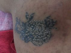 a close up of a person's chest with a tattoo design on the side