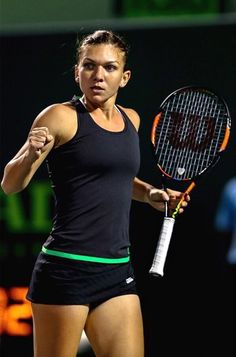 a woman holding a tennis racquet on top of a tennis court with her arm in the air